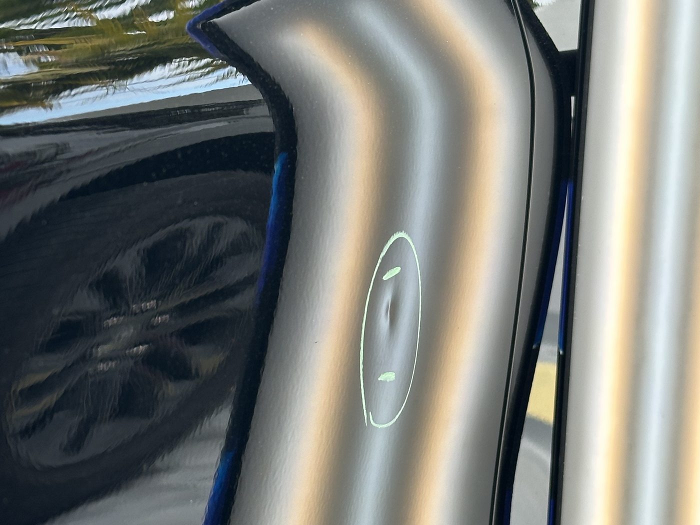 Before paintless dent repair — a dent marked on a black panel, Caliber PDR Miami